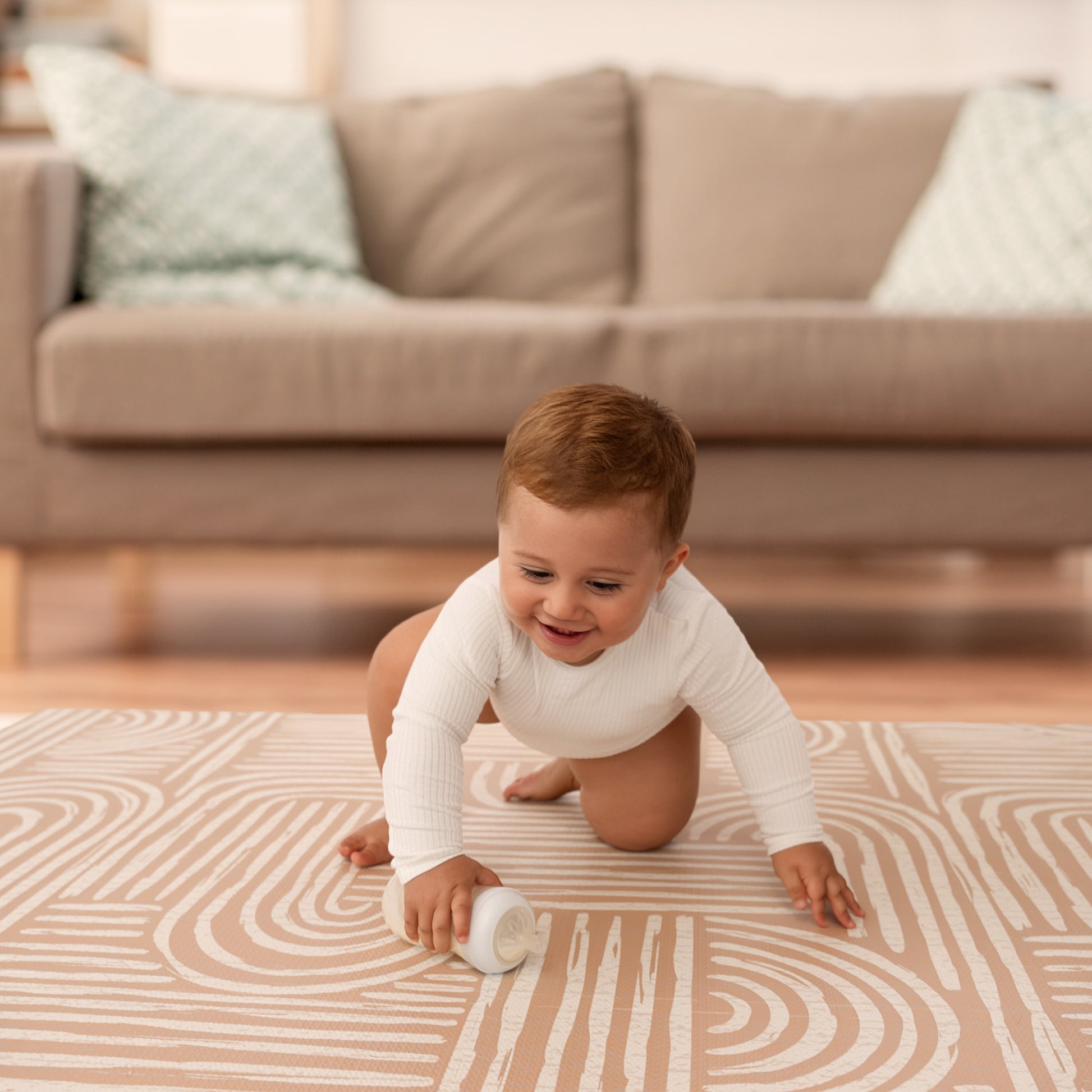 Kleinkind krabbelt auf der beigen Krabbelmatte Baby – sichere Oberfläche für die ersten Krabbelversuche